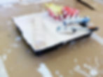 Roller and paint tray with white paint and a brush