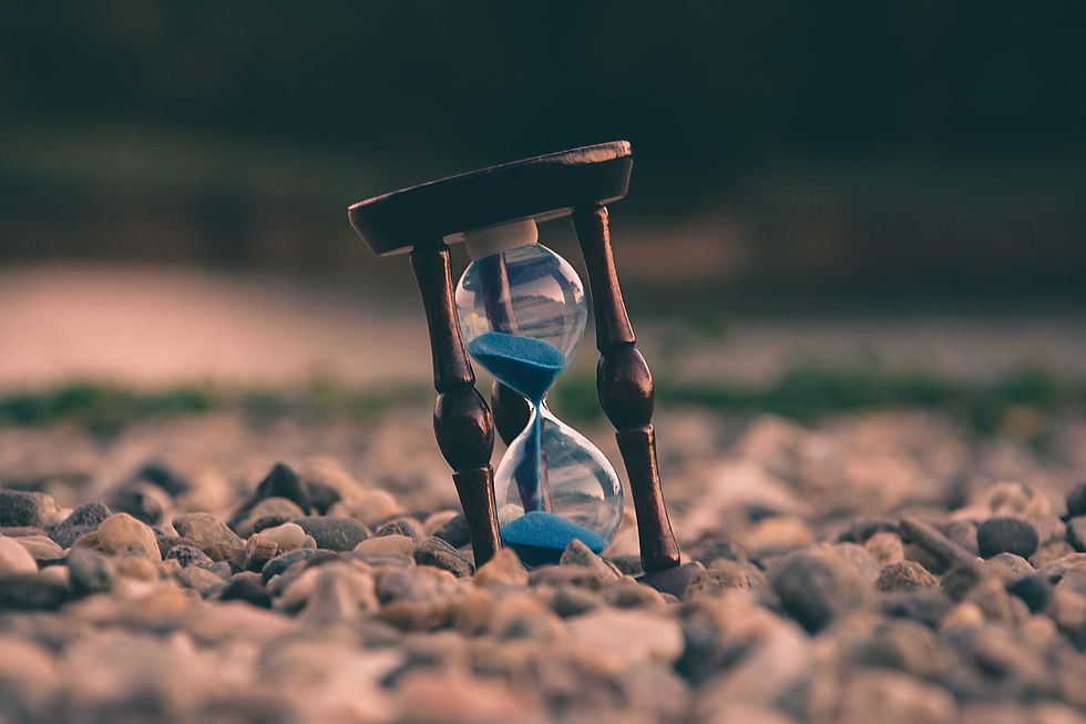 Image is sourced from Aaron Visuals on Unsplash. Sand timer on the beach.