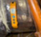 Orange digital thermometer reading 72.1°F attached to a reflective surface, with wooden and plastic elements visible in the background.