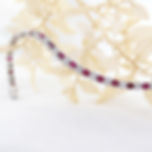 Luxurious white gold tennis bracelet, showcasing a pattern of princess cut rubies paired with brilliant round diamonds.