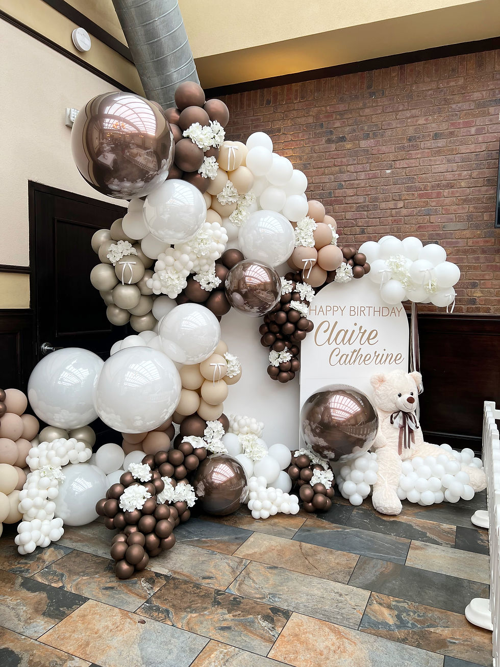 Brown and white organic balloon decor arches for a first birthday