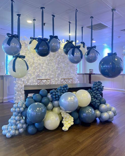Suspended navy and yellow balloons with coordinating organic balloon table front garland at a Long Island event.