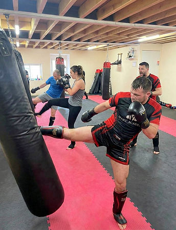 Sportifs pratiquant du muay thaï dans une salle de sport.