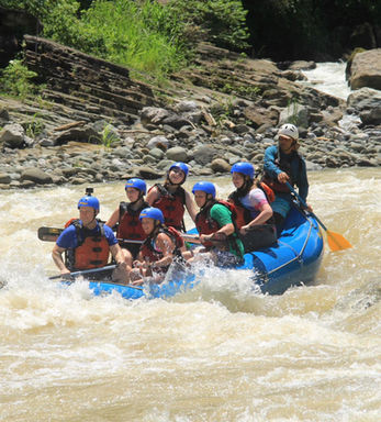 Group of people in a blue raft Whitewater Rafting in Costa Rica