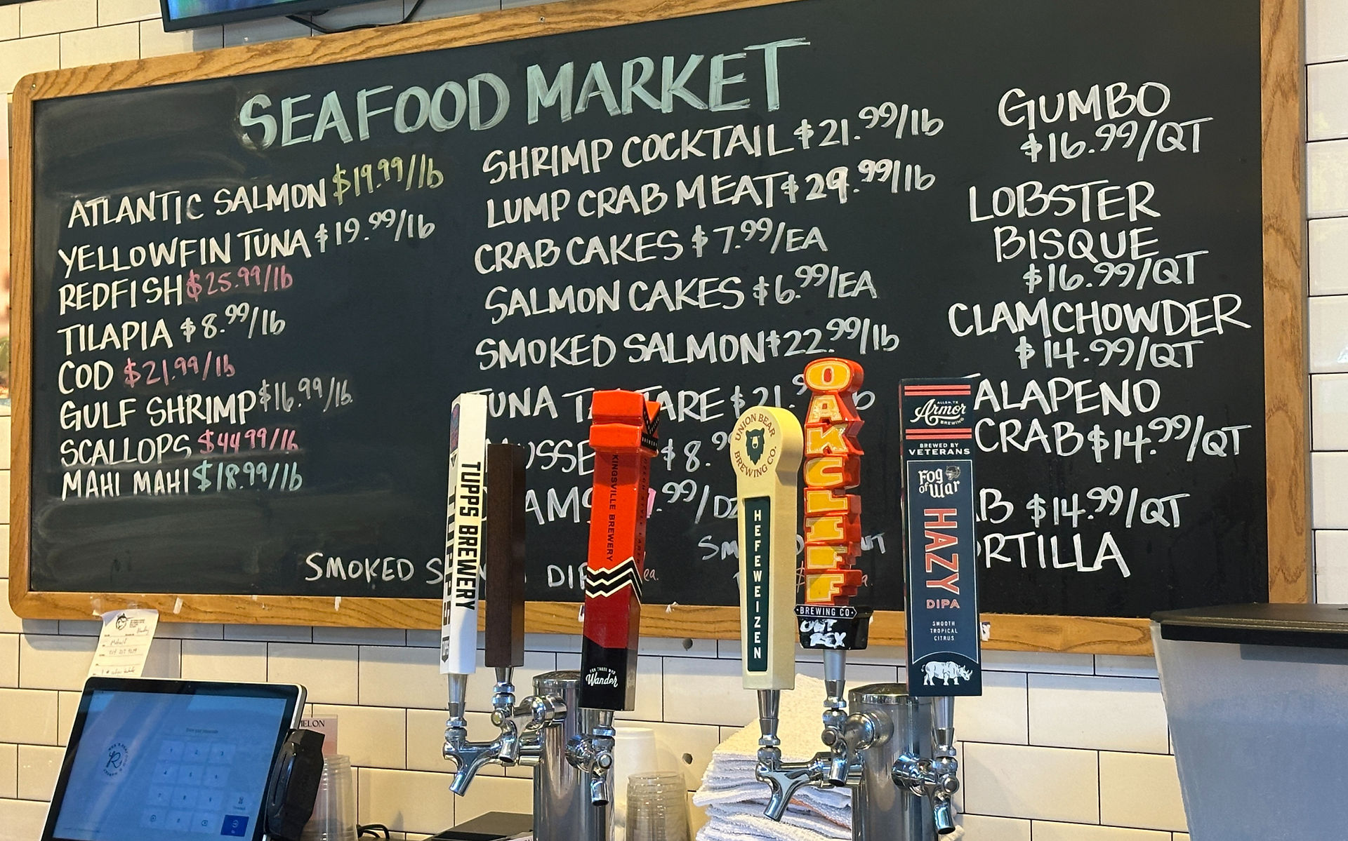 Beer tap with a Seafood Market sign hanging behind it