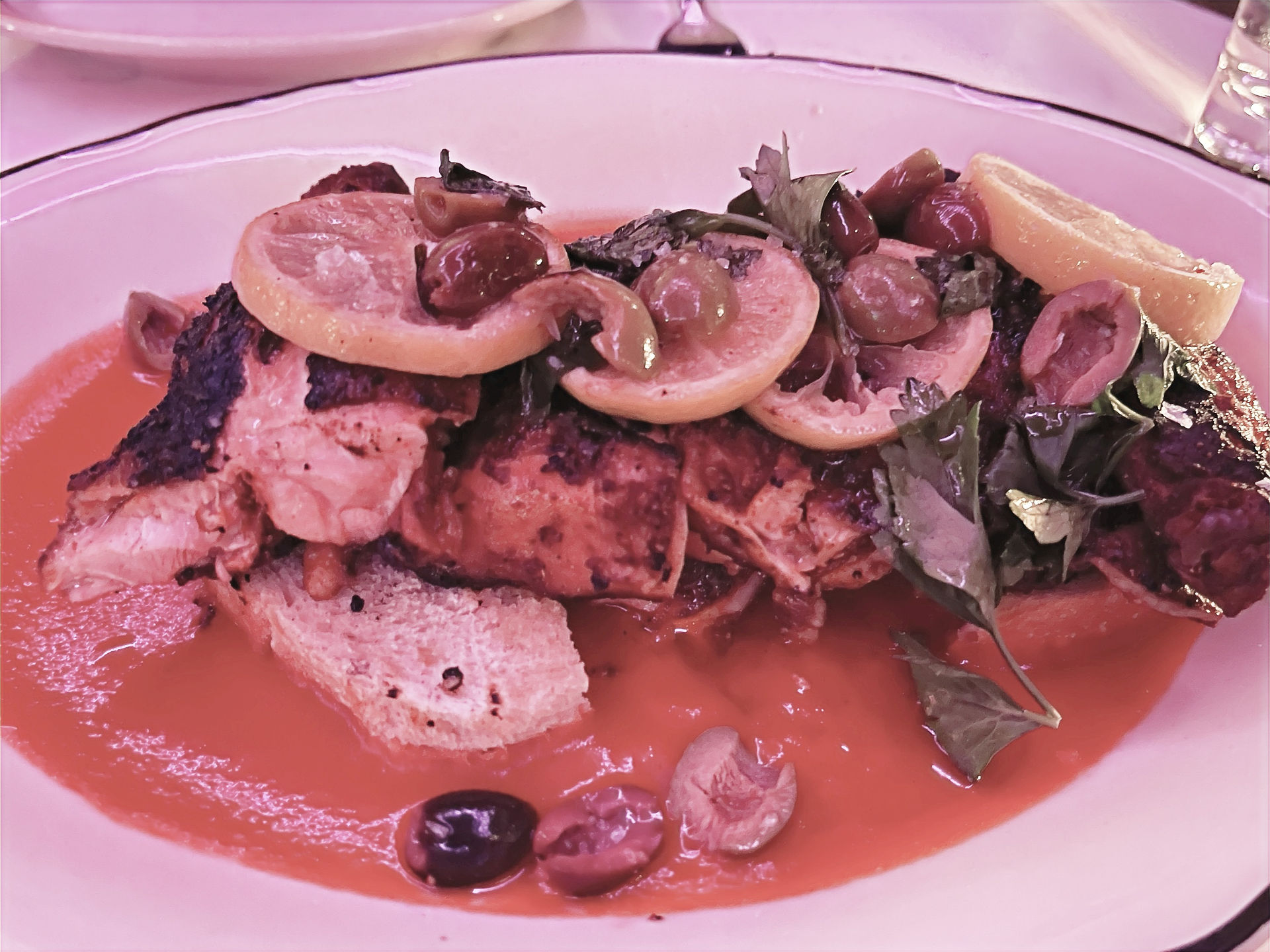 Chicken with lemons on top of a red sauce