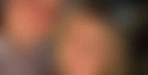 Man and woman with Acropolis in Athens in the background at night