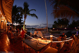 Baci Ristorante patio lit up at night with sailboat in the background in Turks and Caicos