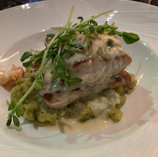 fish on green rice with a white cream sauce