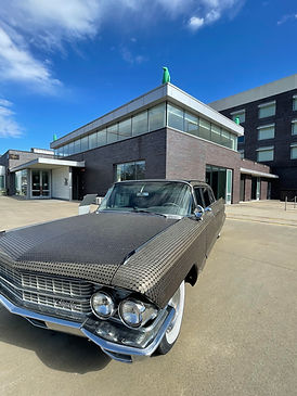 Old Classic car covered in coins sitting in front of the 21c Museum Hotel Bentonville, Arkansas