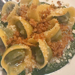 white bowl with pasta and green sauce