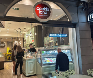 Man standing outside of Cookie Land store in Athens looking at a Gelato counter