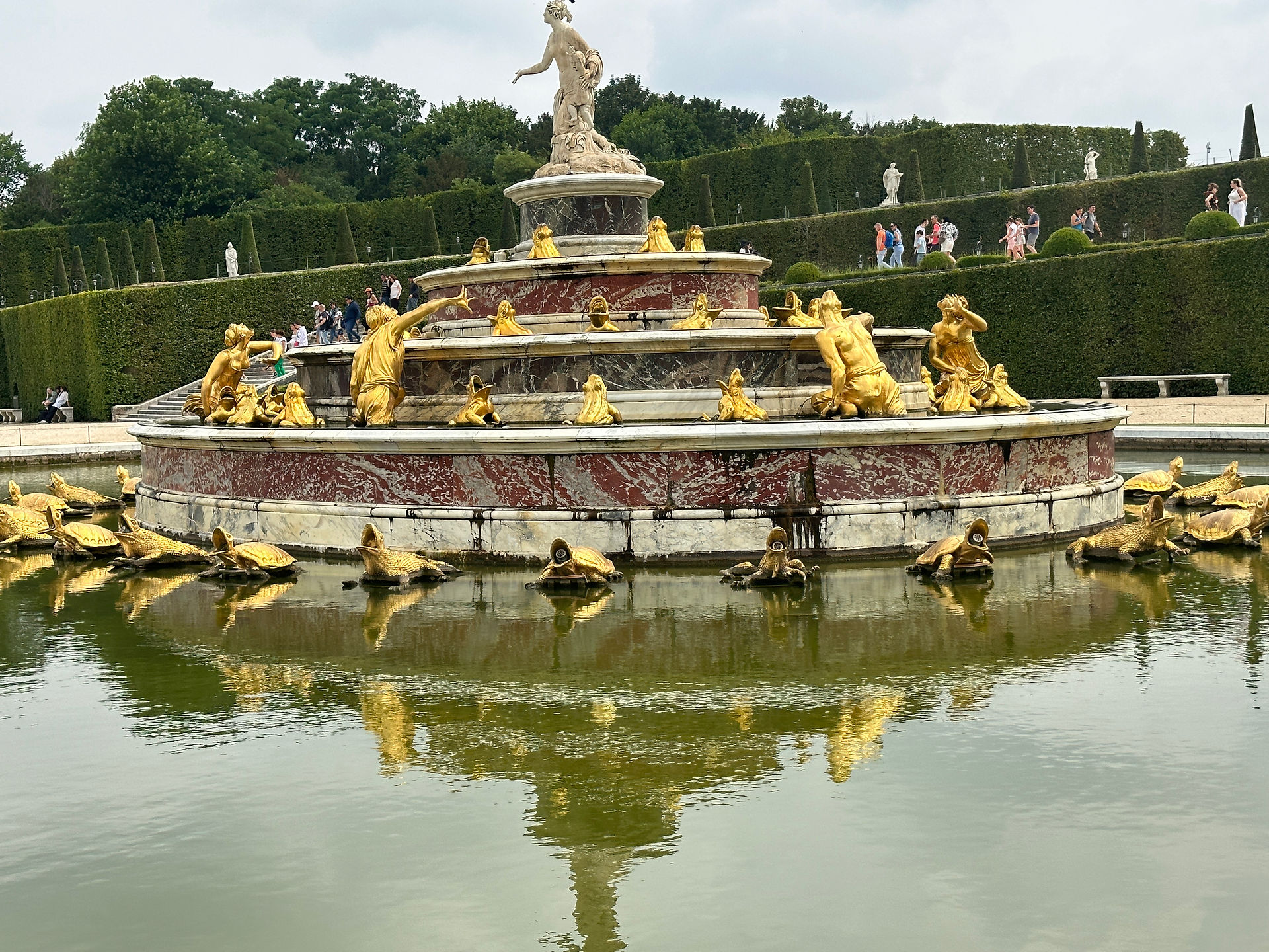 Large fountain with gold sculptures at the Palace of Versailles gardens