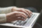 Hands typing on laptop