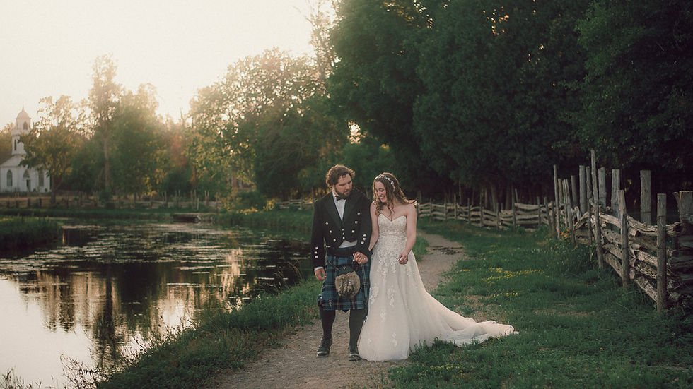 Couple walking along a riverside path at sunset during an intimate countryside wedding in Ottawa, natural light wedding photography.