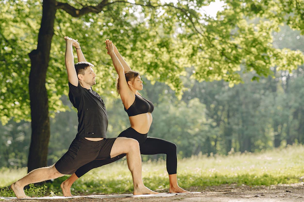 joven-pareja-deportiva-haciendo-yoga-fitness-personas-parque-verano_1157-40151.webp