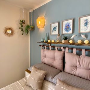 Coastal bedroom. Ocean inspired colours, sea themed art, hanging plants and and natural wood shelf