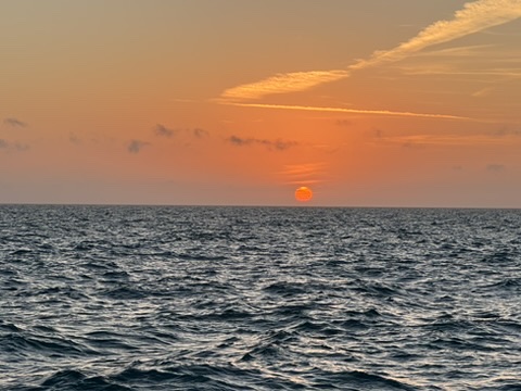 Sunset over the ocean in Eleuthera, Bahamas, with vibrant colors reflecting off the water, creating a breathtaking tropical view.