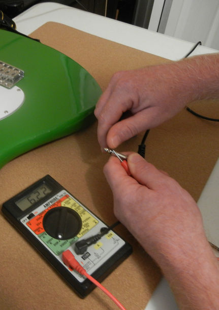 Using a multimeter on a guitar.