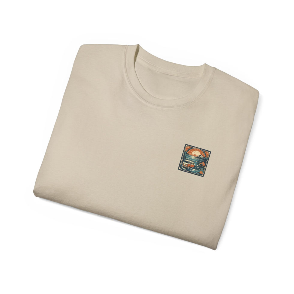 Folded beige t-shirt with a small graphic of a sunset scene featuring a camper van, mountains, and trees