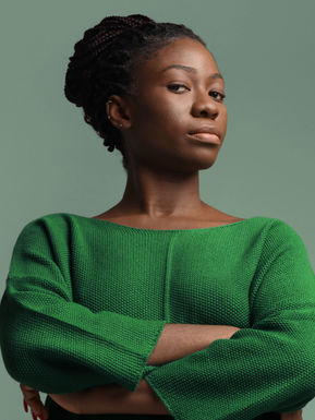Confident woman in green with arms crossed