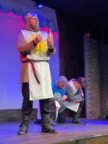 a man in a knight costume is holding a cross