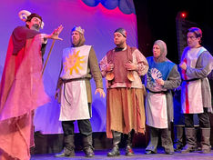 a group of men in medieval costumes stand on a stage