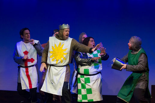 a man with a crown on his head is surrounded by other people