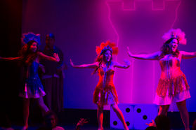 a woman in a red dress is dancing on a stage