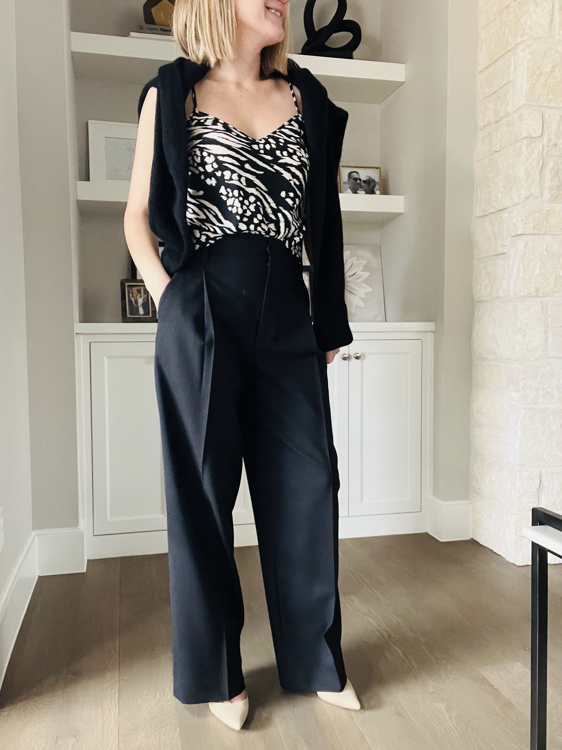 Natalie, top Austin personal stylist, wearing a sweater over the shoulder, printed camisole and black trousers