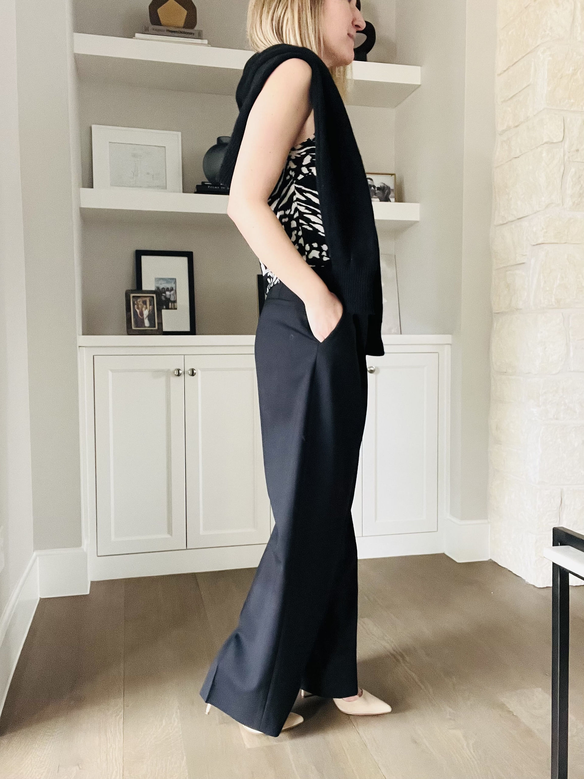 Natalie, top Austin personal stylist, wearing a sweater over the shoulder, printed camisole and black trousers