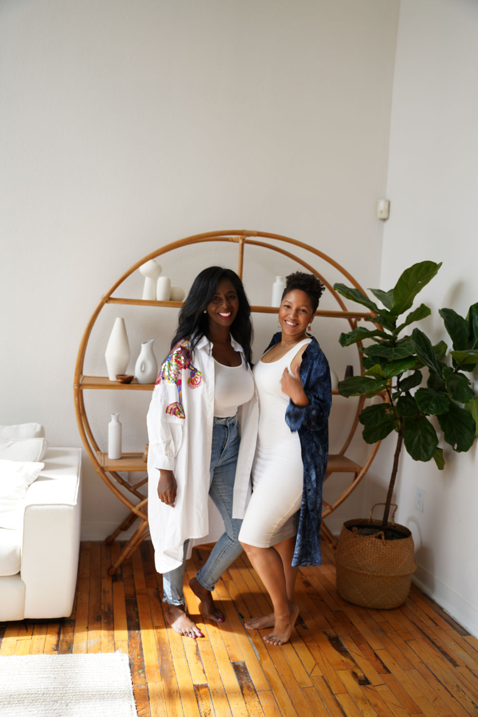 Two creative partners seated on a sofa in a bright contemporary living room during a brand shoot.