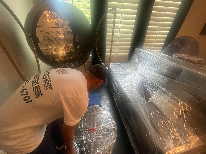 a mover from Armstrong relocation services wrapping furniture