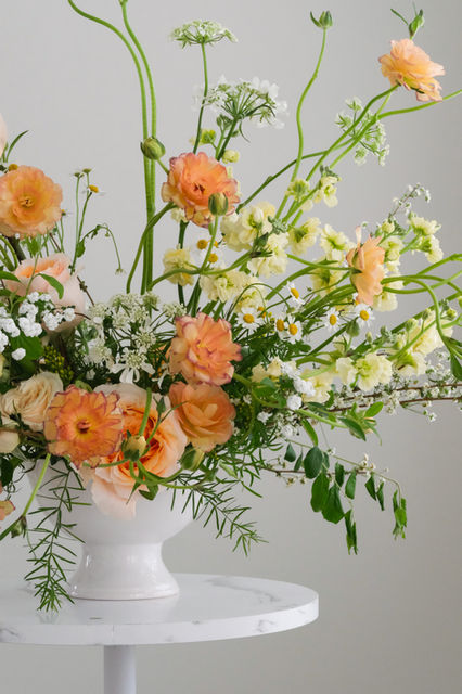 Expressive, spring-themed floral centerpiece with yellow and orange florals.