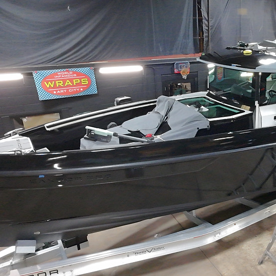 Black boat wraps and graphics on a vessel in a garage.