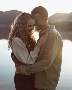 Couple laughing together during golden hour by Derwentwater in Keswick