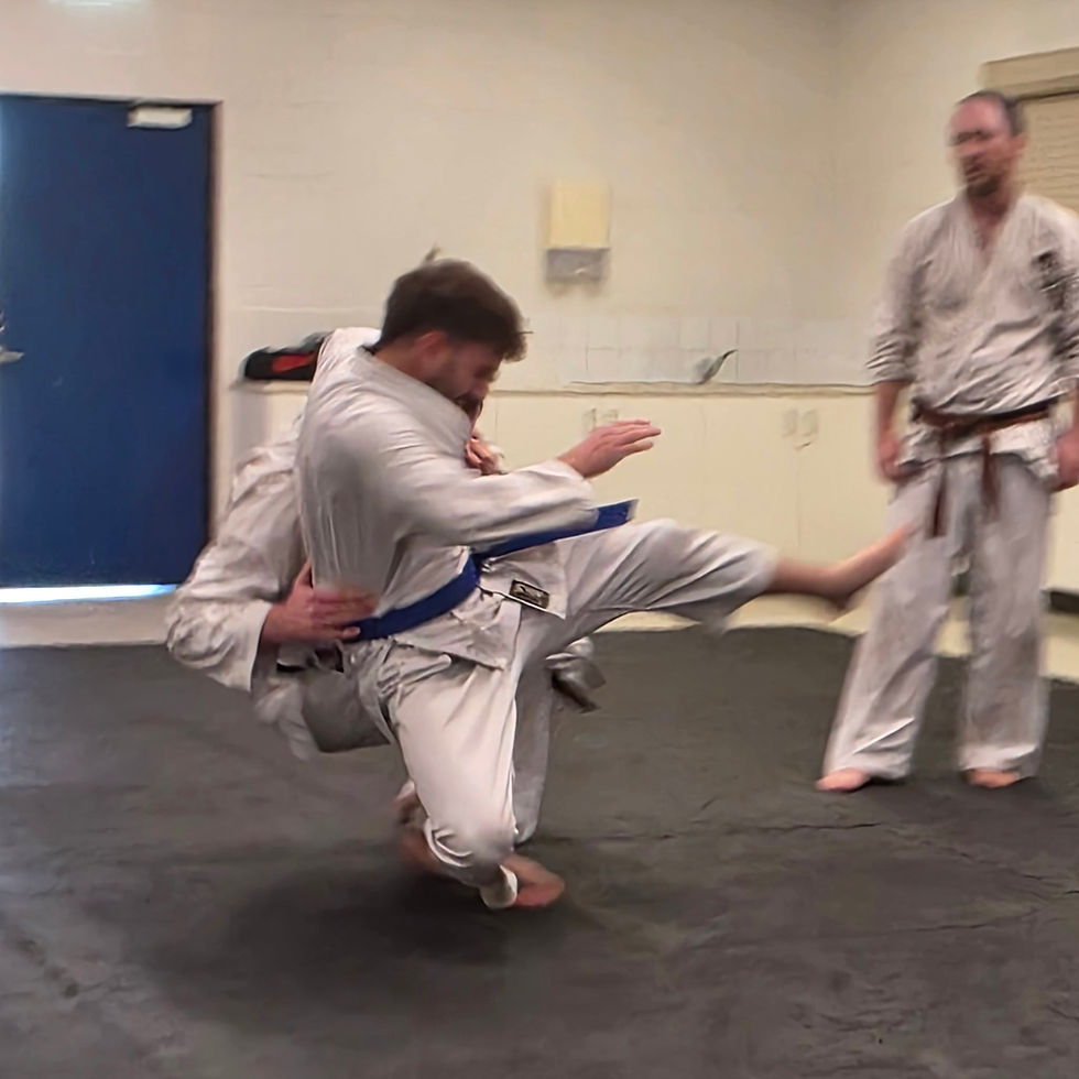 Adult students executing a takedown during a jujutsu class