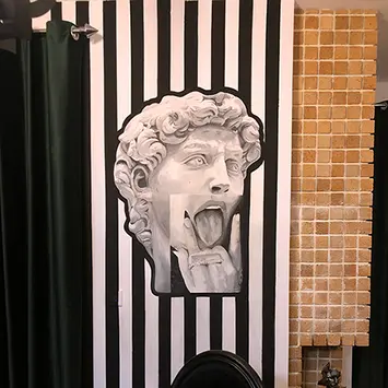 A contemporary black-and-white mural featuring a modern interpretation of Michelangelo’s David sculpture with a surreal expression.