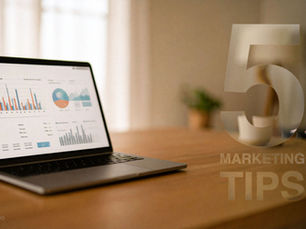 A MacBook on a wooden desk displaying marketing charts, with a subtle '5 Marketing Tips' overlay, symbolizing small business growth strategies inspired by Apple.