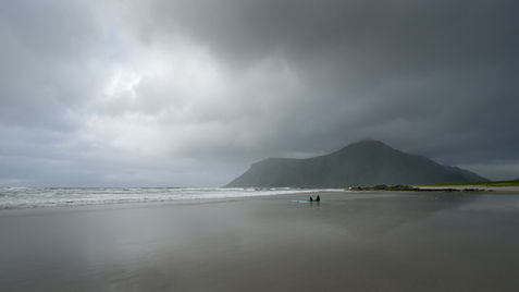 A rainy and cloudy day at Skagsanden with a couple of surfers sitting on the beach