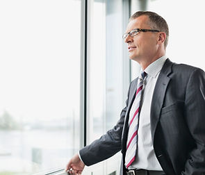 El hombre de negocios mirando por la ven