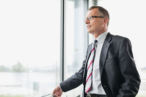 El hombre de negocios mirando por la ven
