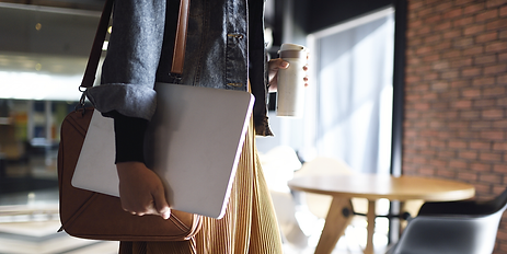 Person carrying a laptop and a thermos
