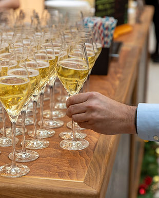 Bar with pre-poured prosecco and a person taking a glass