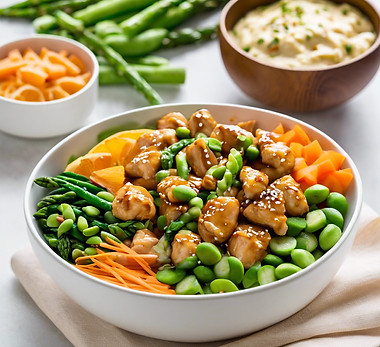 round bowl of orange chicken, cucumber, carrots, edamame, spinach, asparagus cheese and a