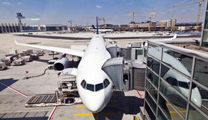 jet on ramp with airbridges attached and ground service vehicles nearby
