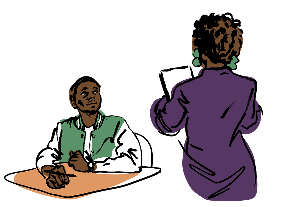 a student in a varsity jacket is sitting at a desk looking up at a teacher