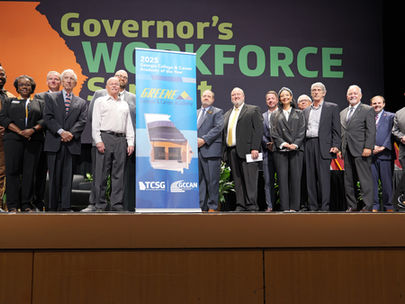 A group of people stand onstage with a "Governor's Workforce Summit" backdrop and a banner for 2025 Greene College & Career Academy.
