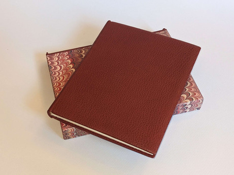 reliure artisanale en cuir et papier marbré sur un ancien livre, réparation des papiers