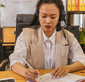 Career coach taking notes during a virtual coaching call.